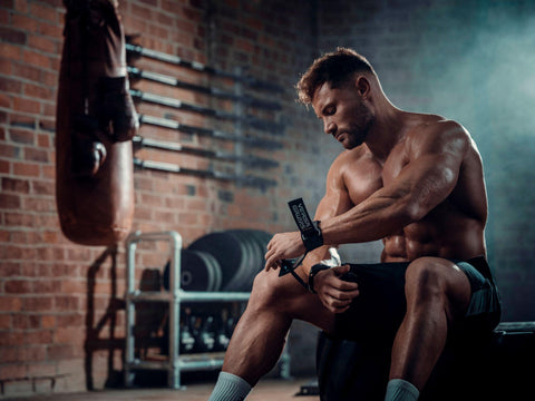 Male weightlifter putting on his Versa Gripps during his workout
